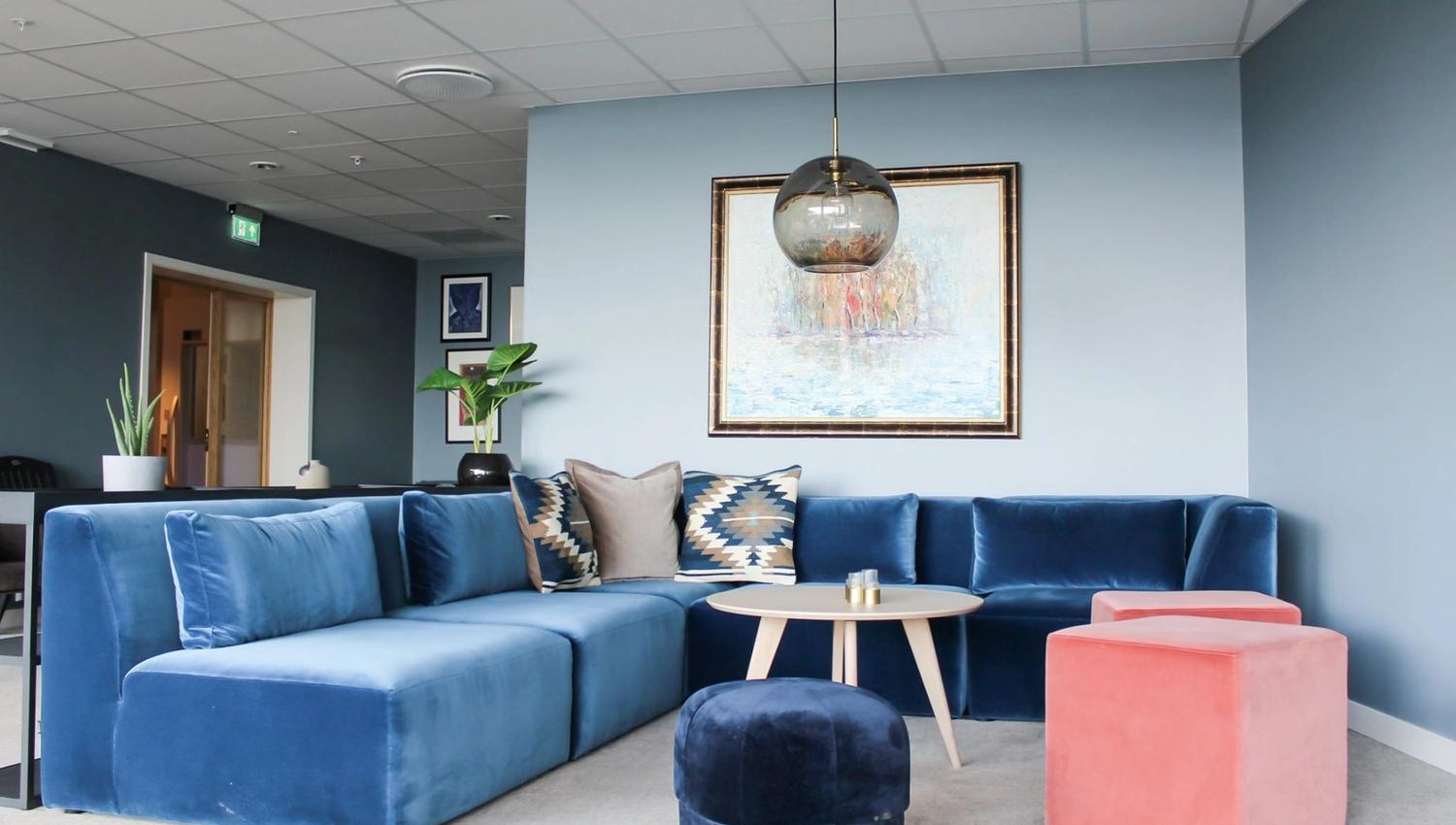 Cozy blue sofa with decorative cushions in a stylish lounge setting.