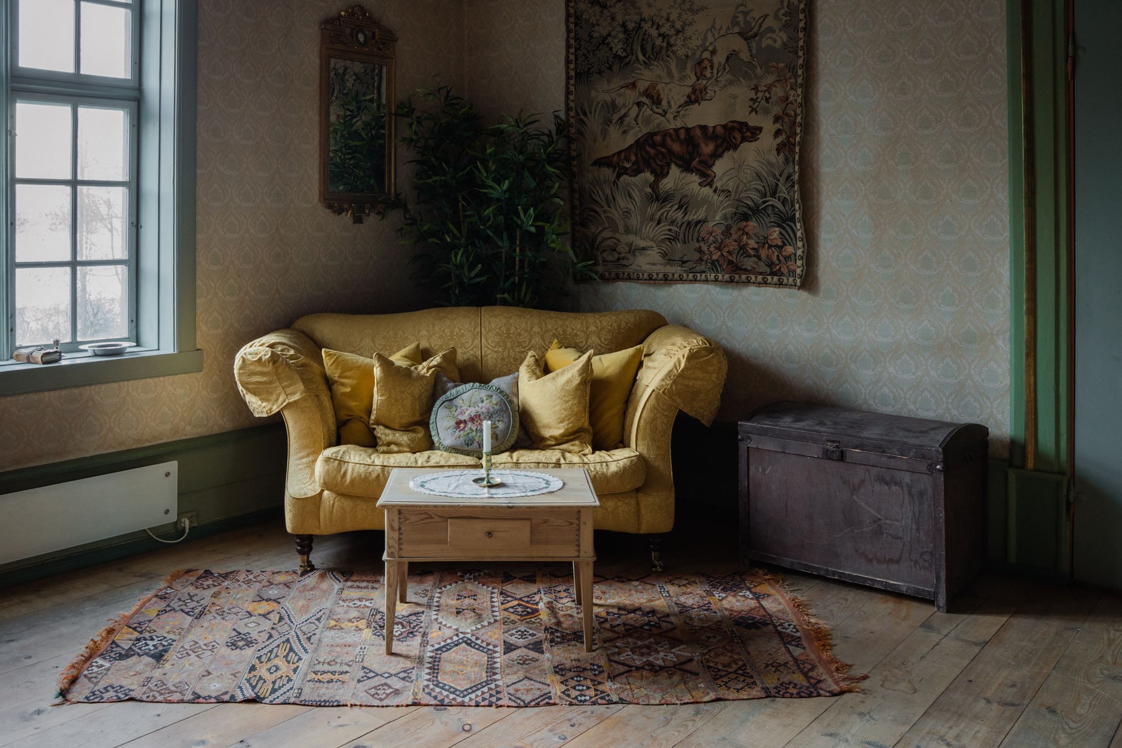 Cosy living room at Skrivergaarden with a sofa, classic furniture and historic details.