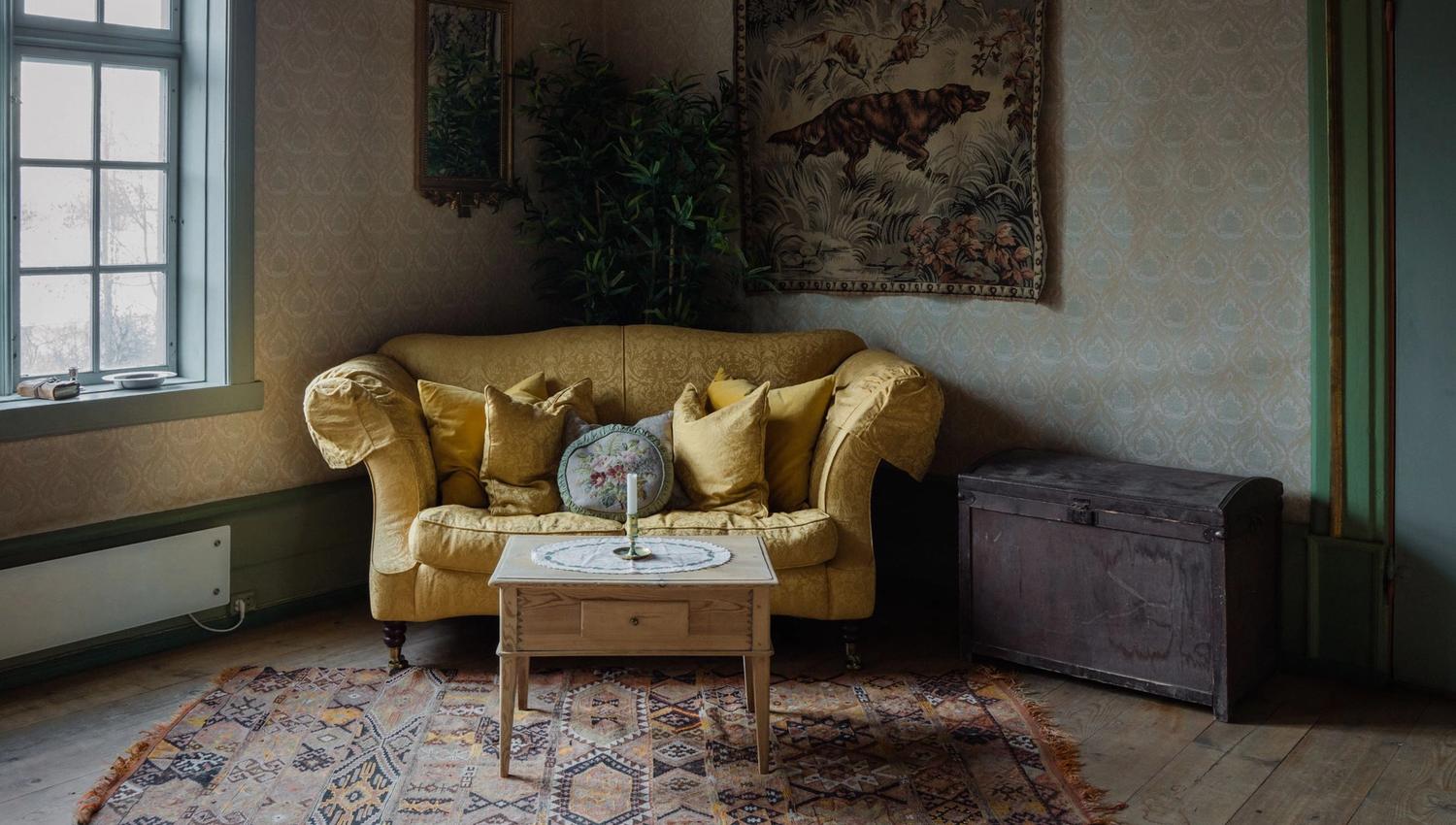 Cosy living room at Skrivergaarden with a sofa, classic furniture and historic details.