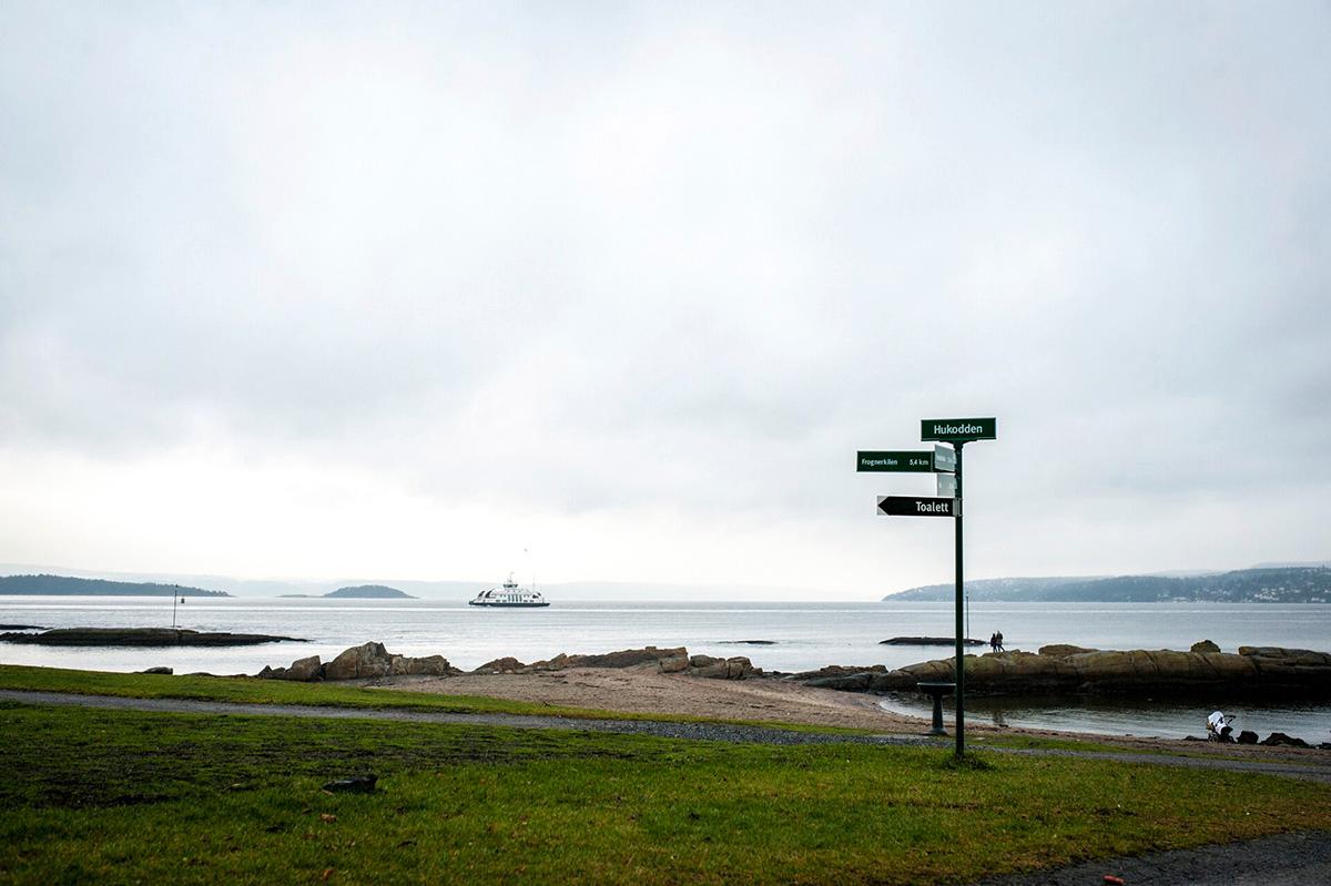 bygdøy beach with a sign and one of the island ferries in the background