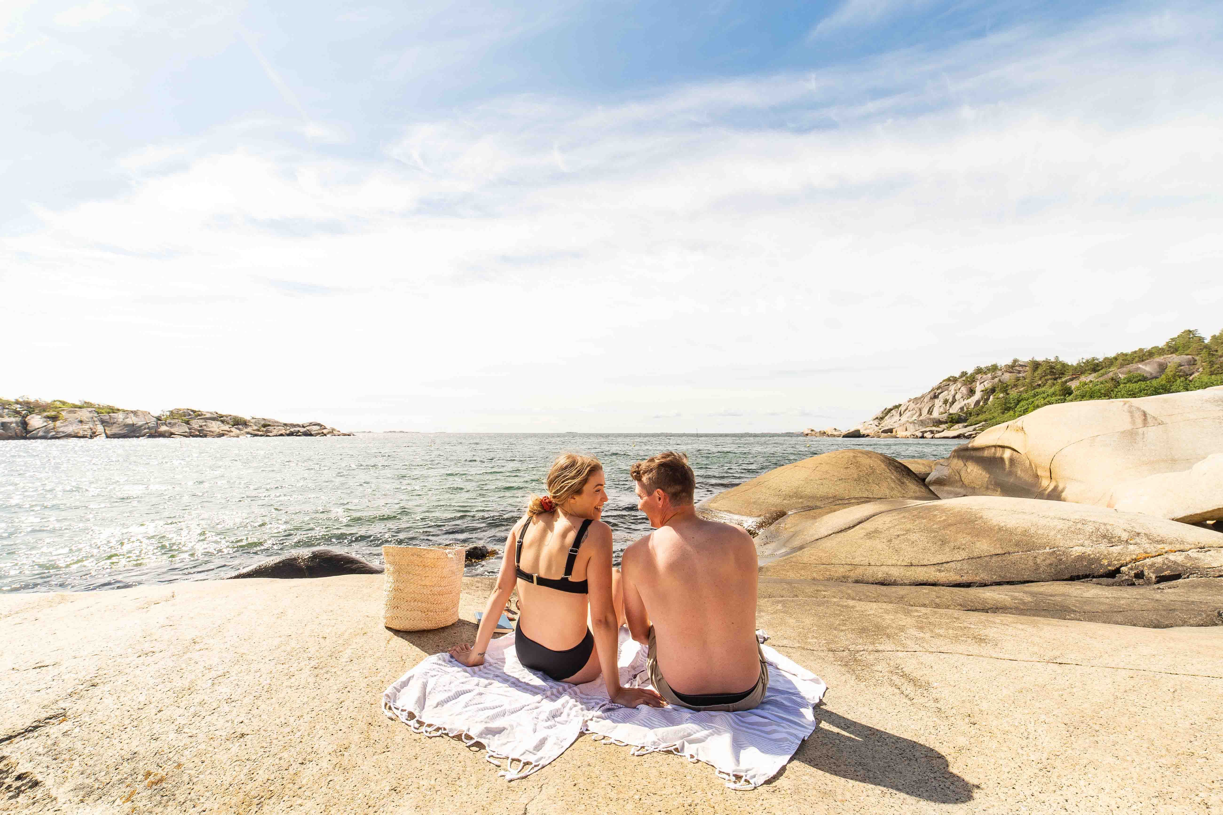 mountain by the water with two people