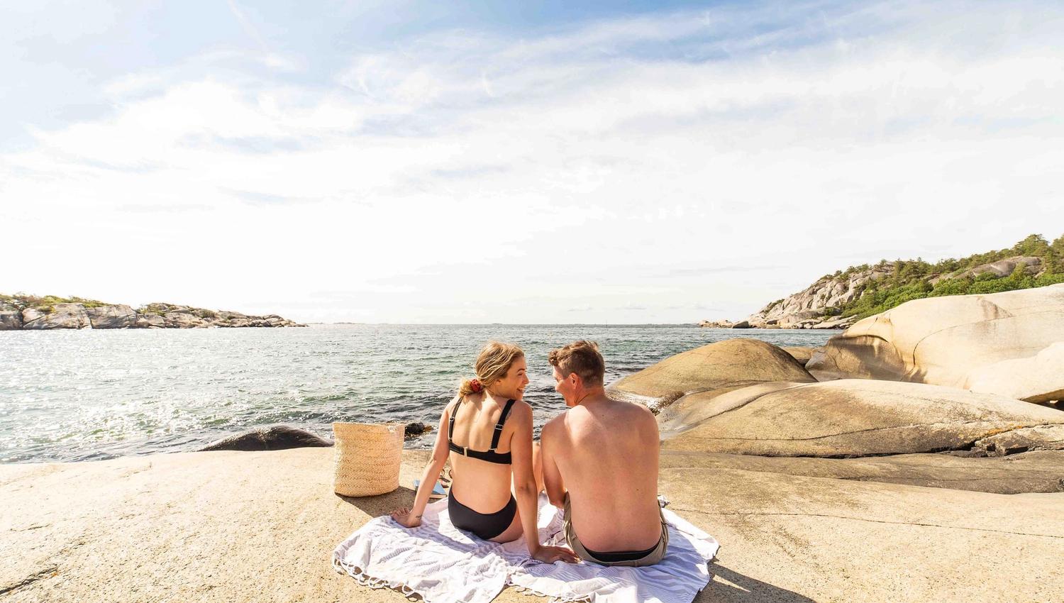 mountain by the water with two people
