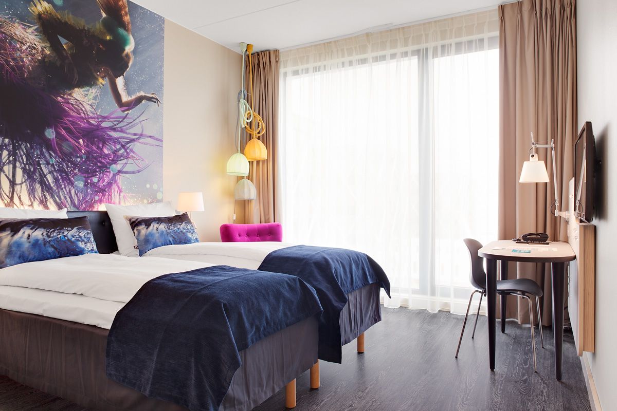 bright double room with two beds and a desk