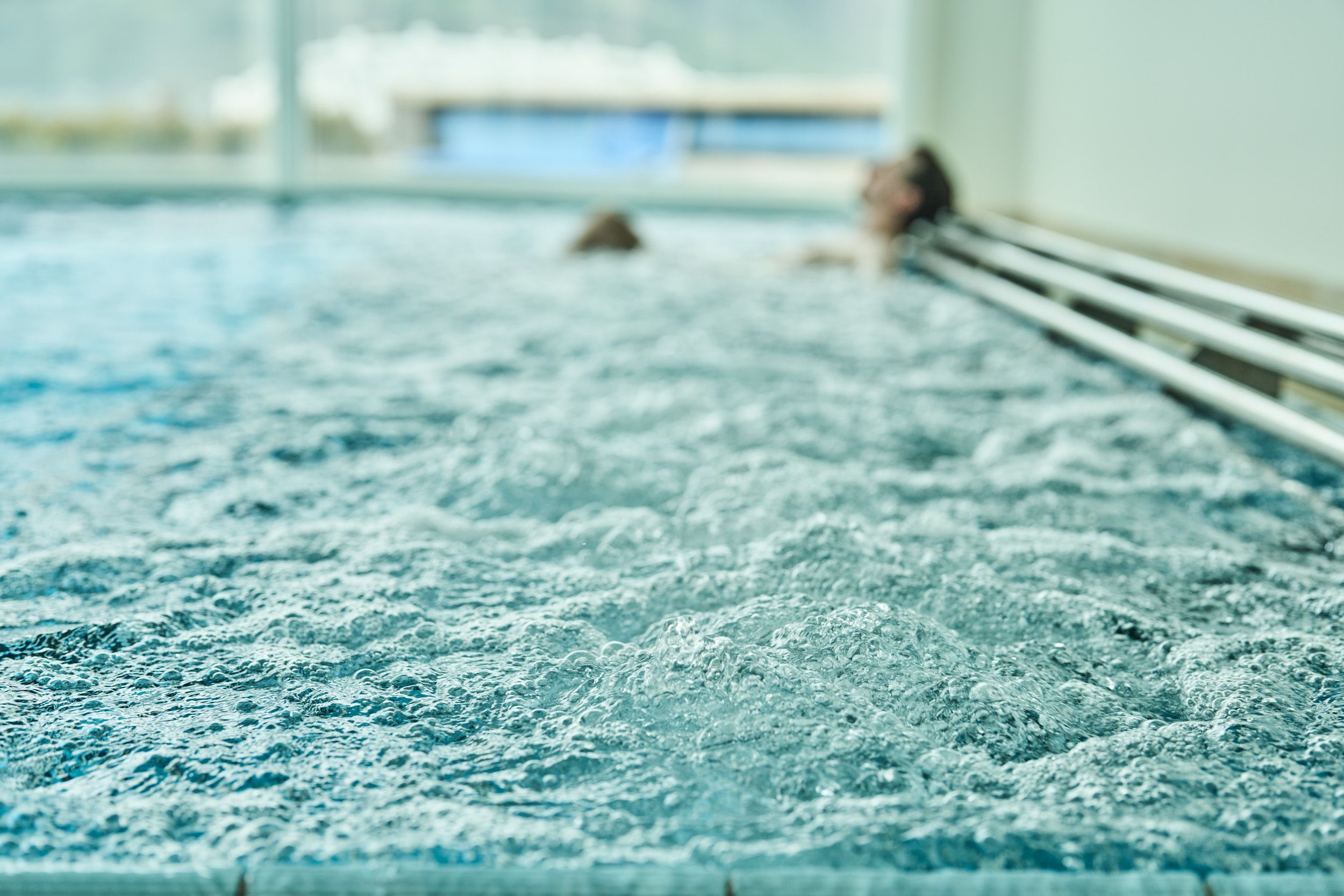 Bubbling hot tub with relaxed guests in the spa area at Hotel Ullensvang.