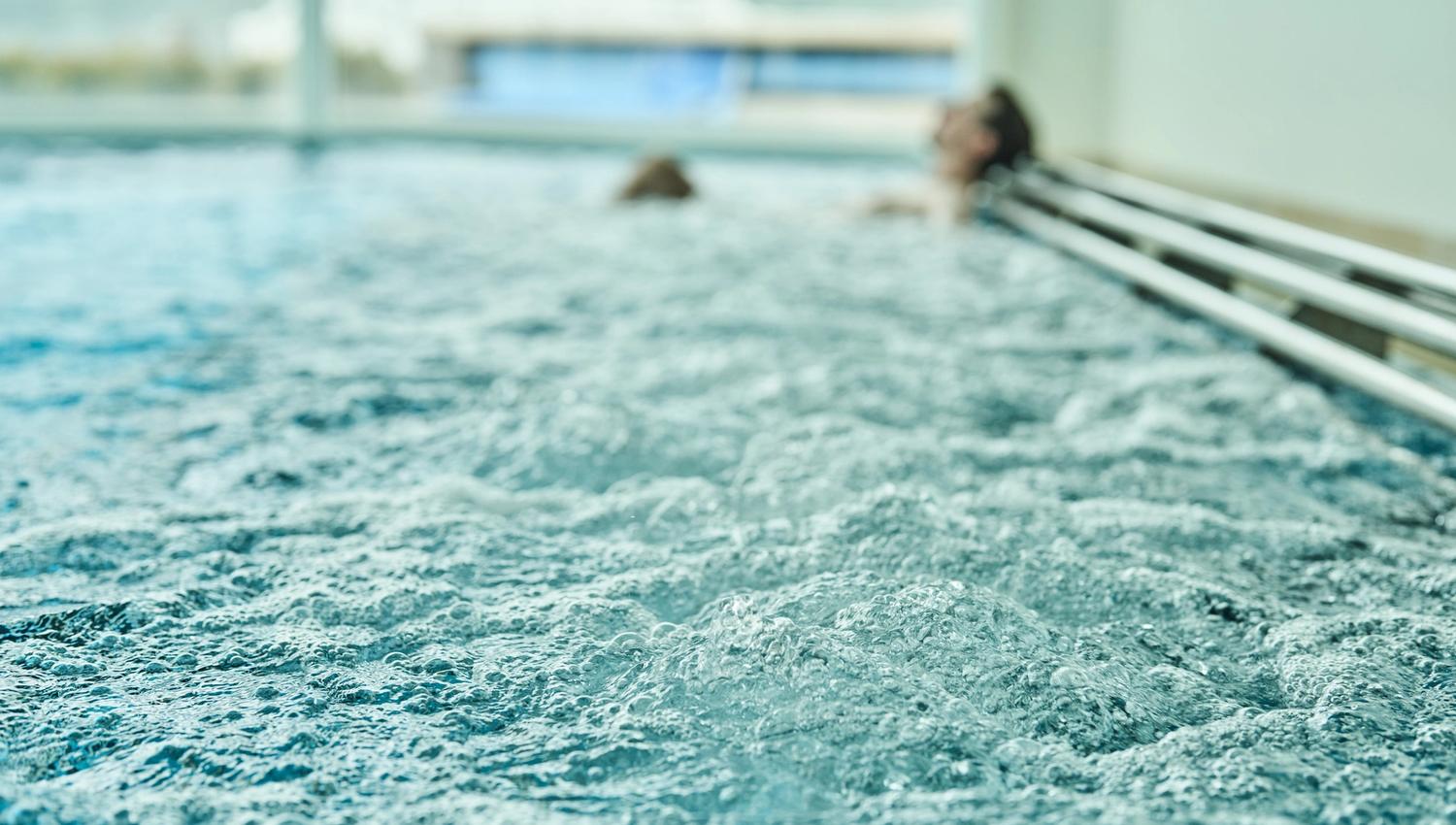 Bubbling hot tub with relaxed guests in the spa area at Hotel Ullensvang.