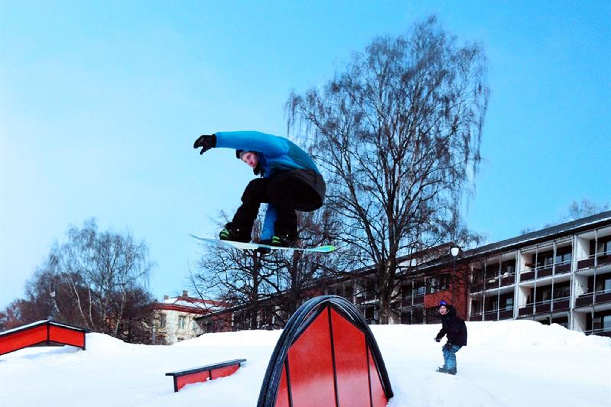Snøbrettkjører som hopper over en rampe.