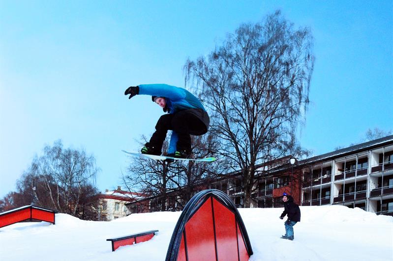 Snøbrettkjører som hopper over en rampe.