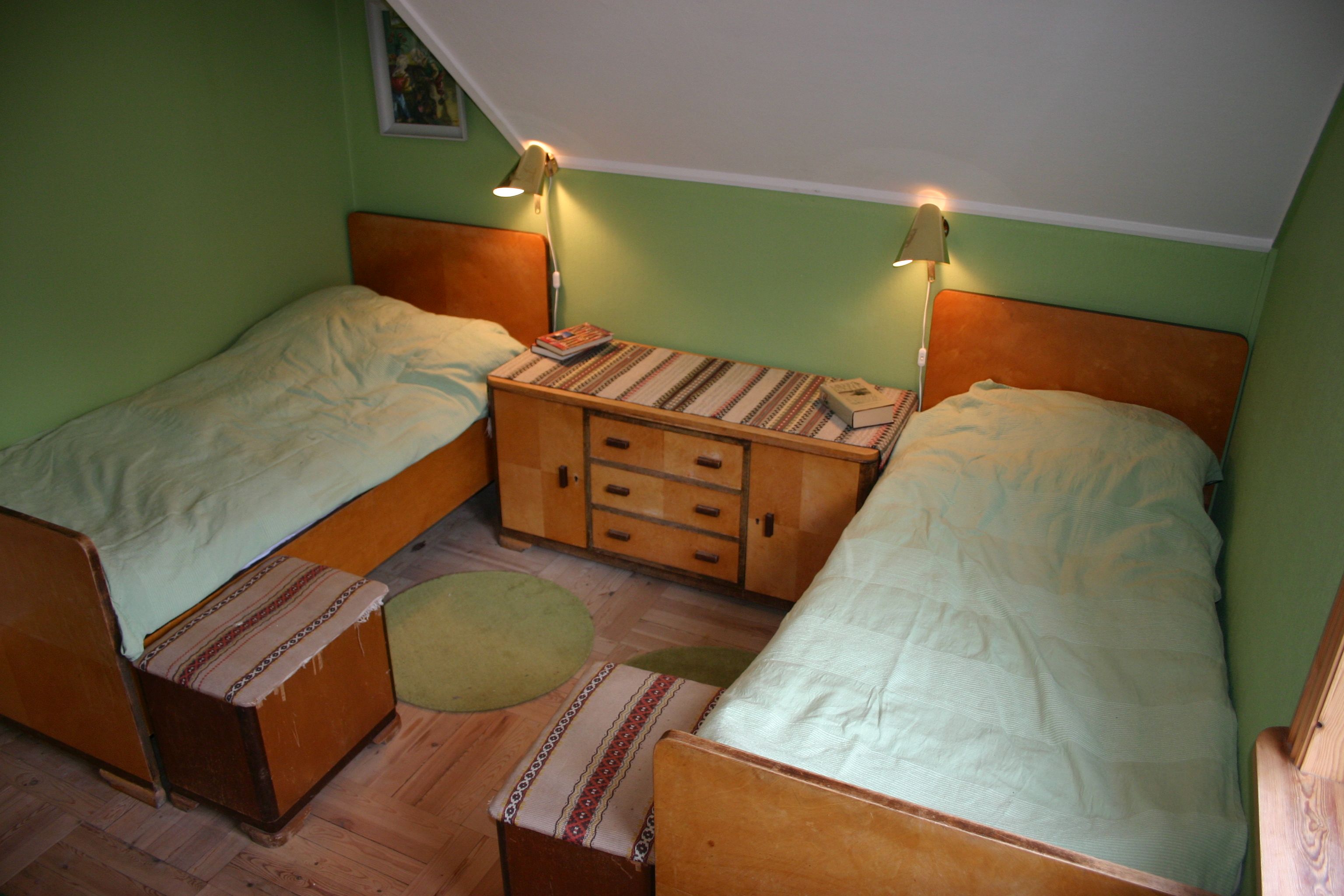 Bedroom with two single beds and green walls at Hardanger Harmoni Fjordhus.