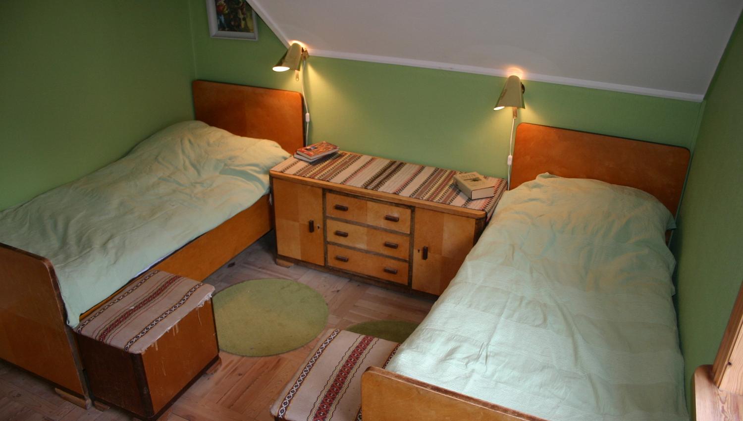 Bedroom with two single beds and green walls at Hardanger Harmoni Fjordhus.