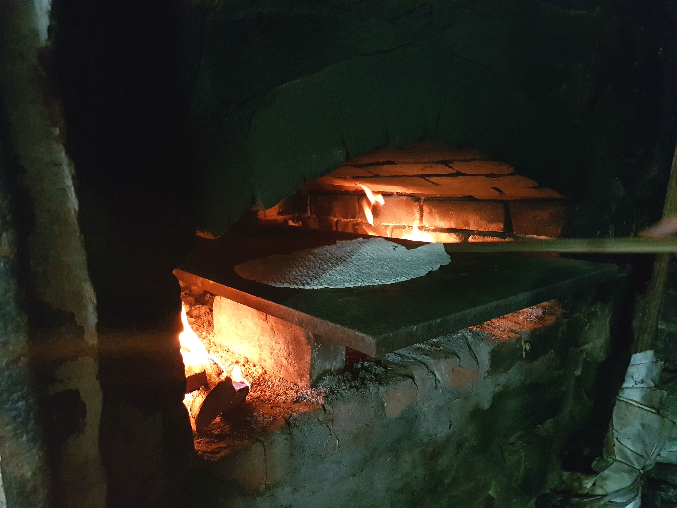 The "krotakaker" are being made in an open wood burning oven  