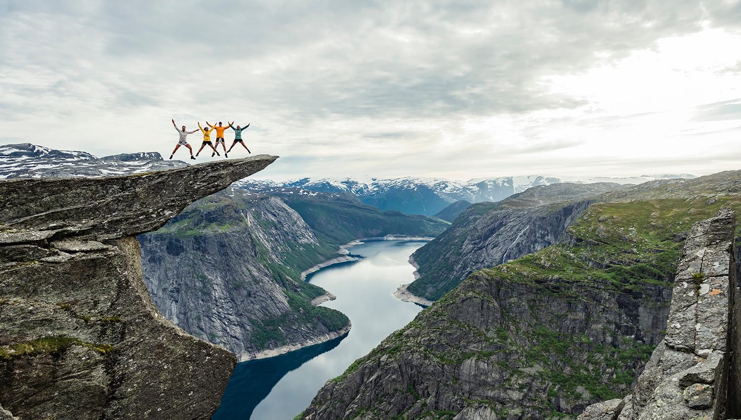 A group of people standing on top of Trolltunga with views towards Ringedalsvatnet lake.