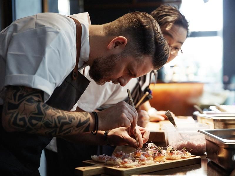 Two cooks prepare some snacks