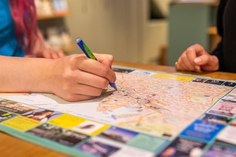 Close-up of an employee’s hand holding a pen and ticking off on a map