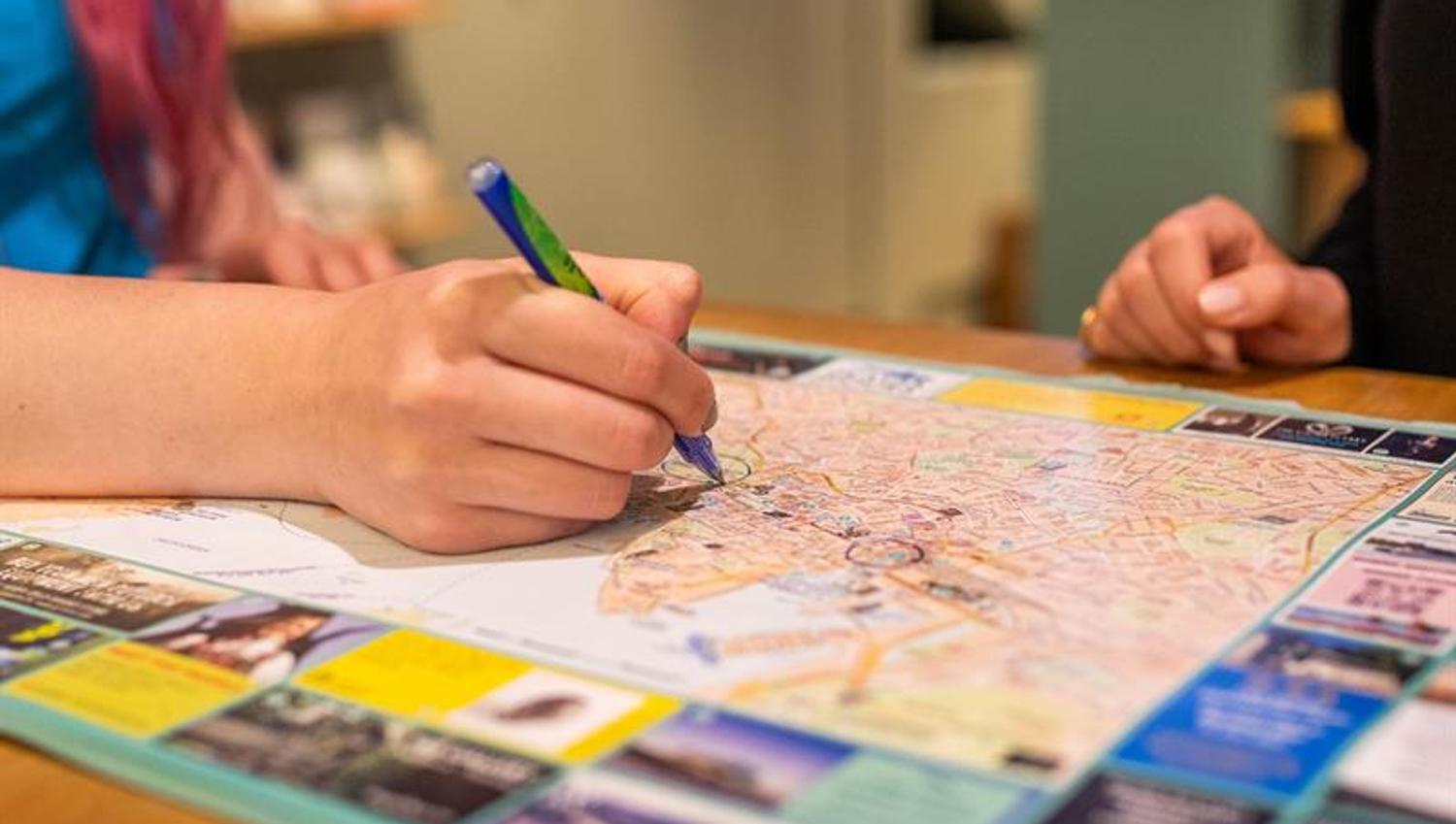 Close-up of an employee’s hand holding a pen and ticking off on a map