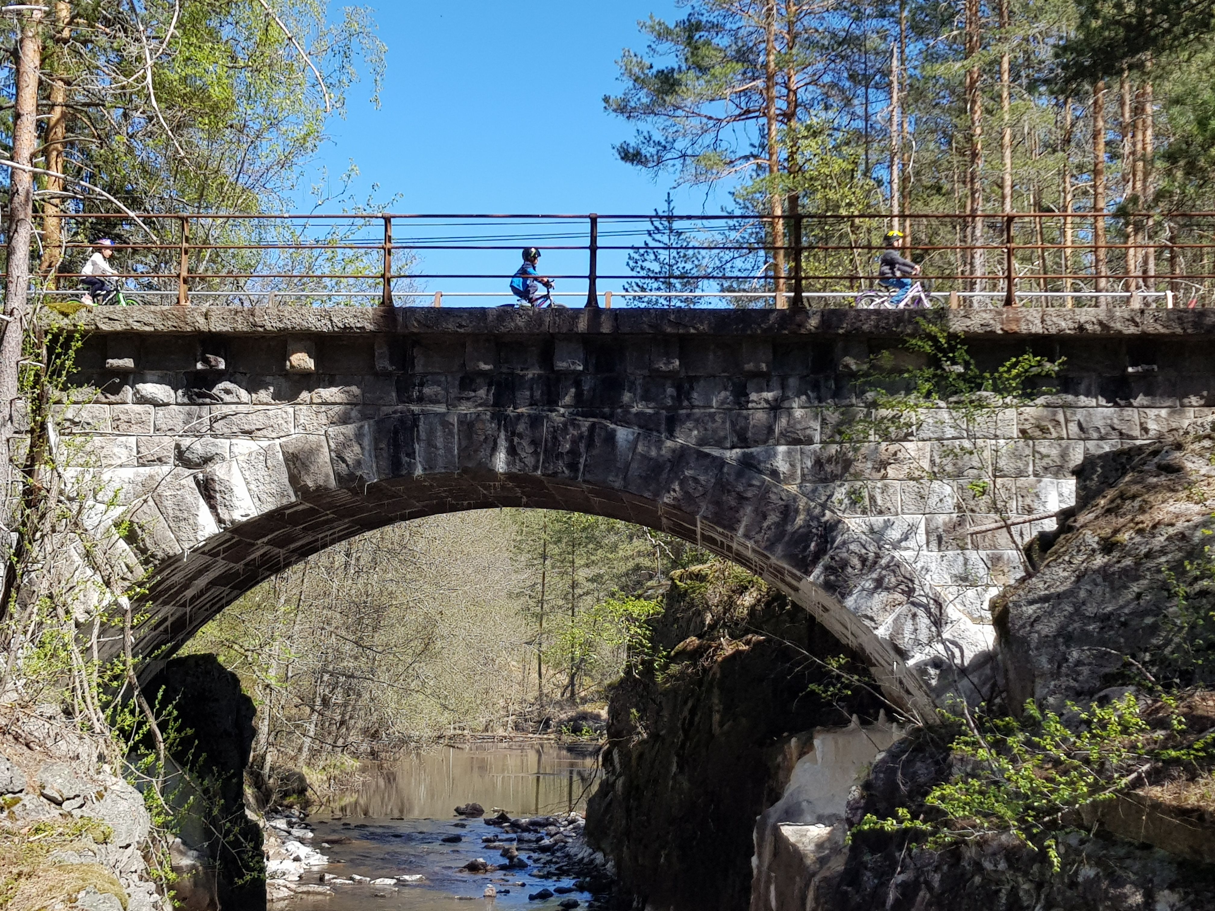 Barn som sykler over en bro
