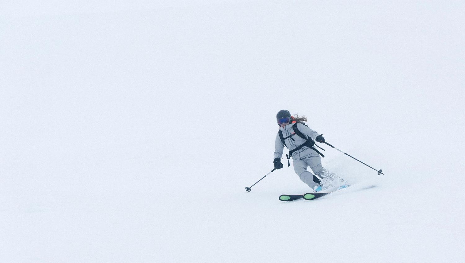 A woman on skiis skiing down a slope.