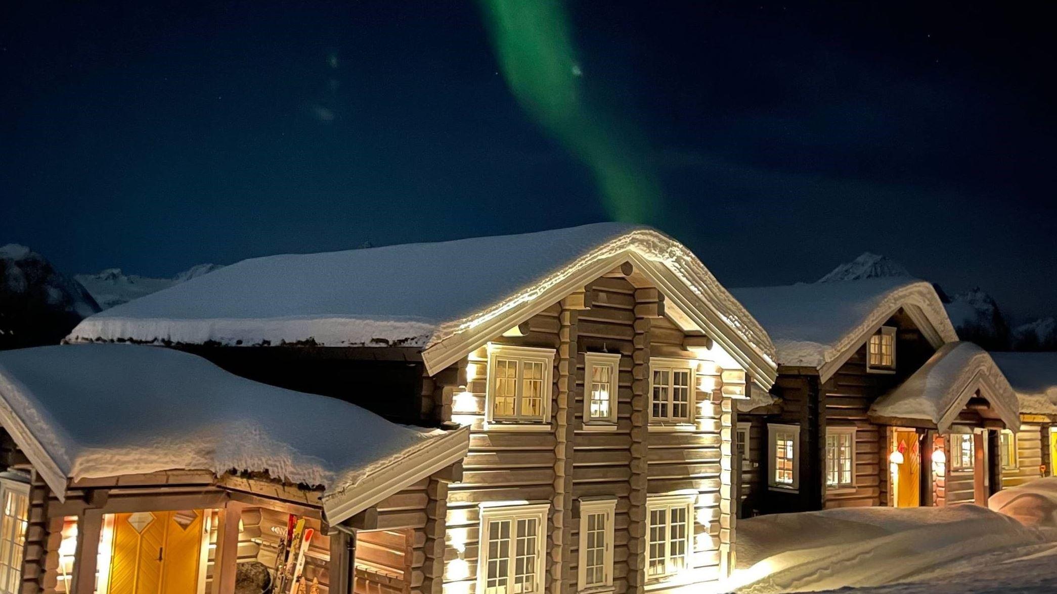 >Lyngen Lodge in winter with the northern lights above the lodge