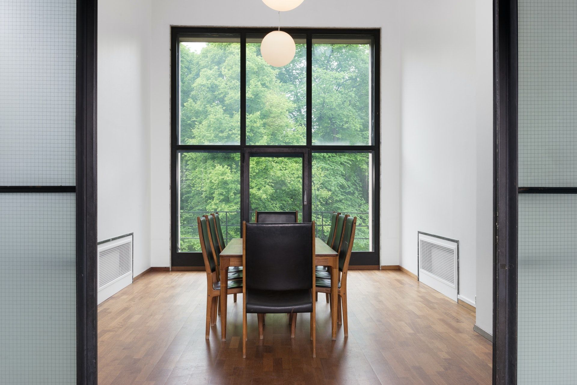 A long table in front of a window with a view towards the park.