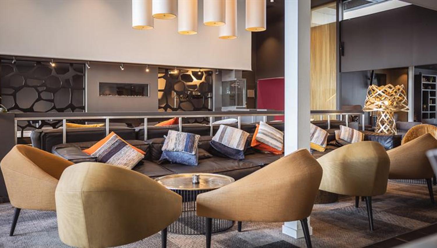 Hotellinngang med moderne arkitektur, parkeringsomrÄde og tydelig skilting