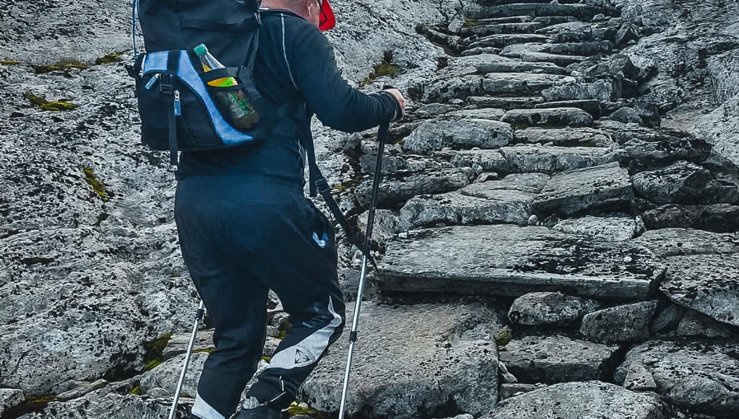 Hiker climbing stone steps in the high mountains of Hardanger, Norway, a classic hiking experience