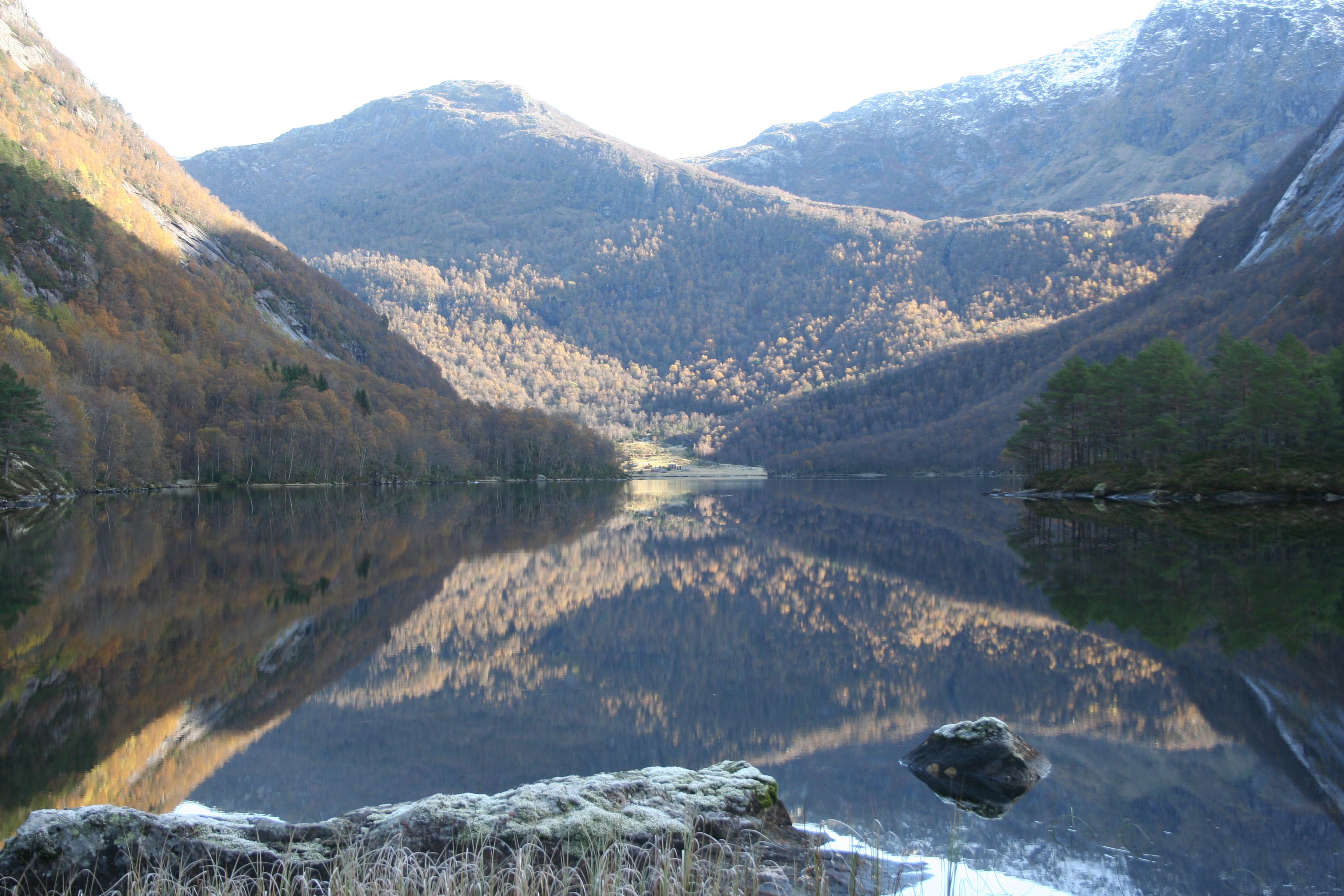 Lake Torsnesvatnet reflecting the autumn colors of the mountains – a tranquil scene from Fjelltveit in Hardanger.