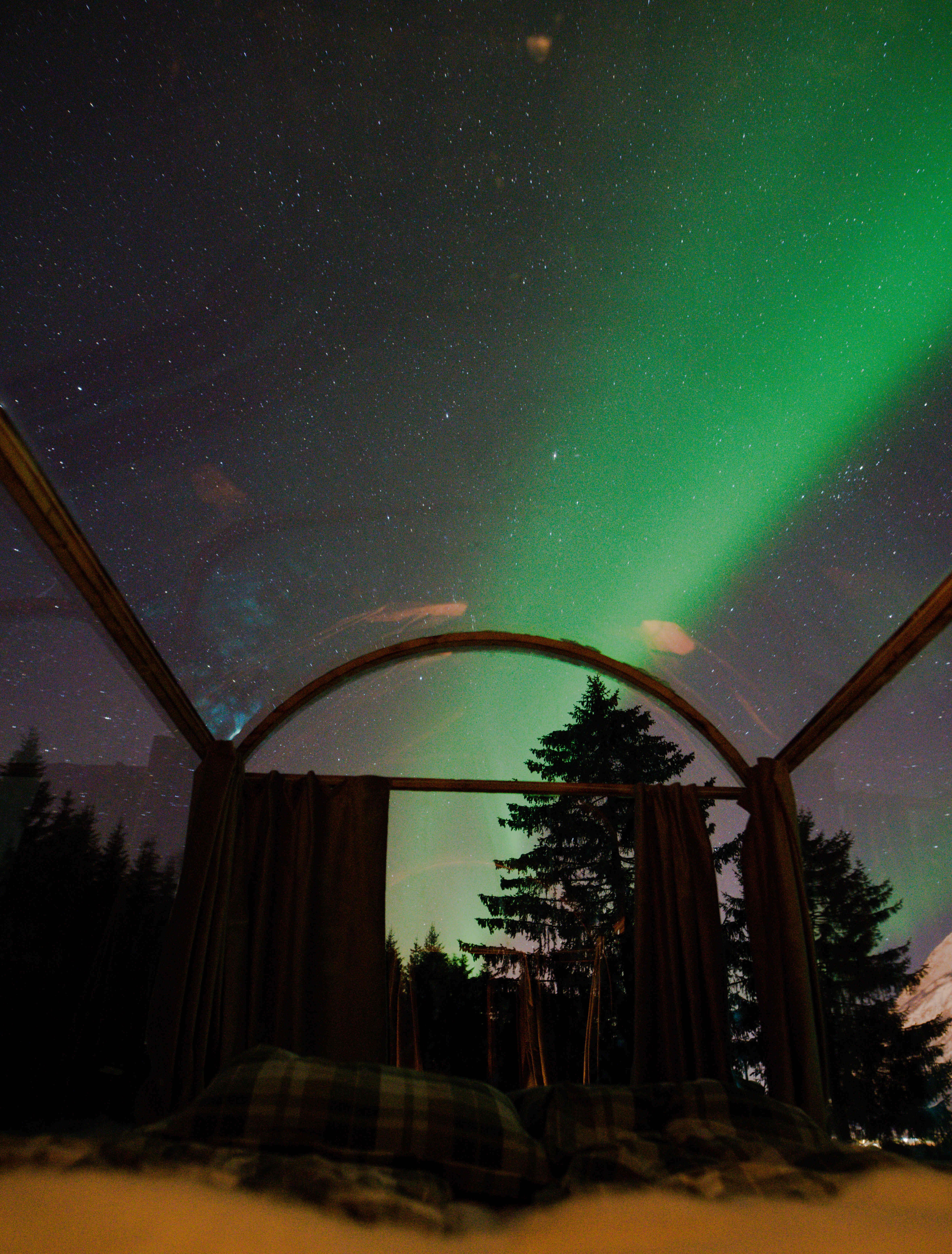 glasshytta med nordlys over