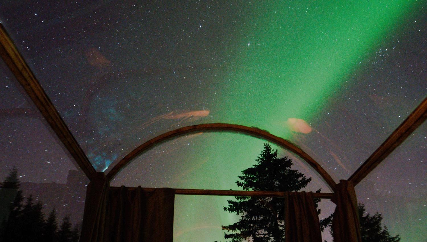 glasshytta med nordlys over