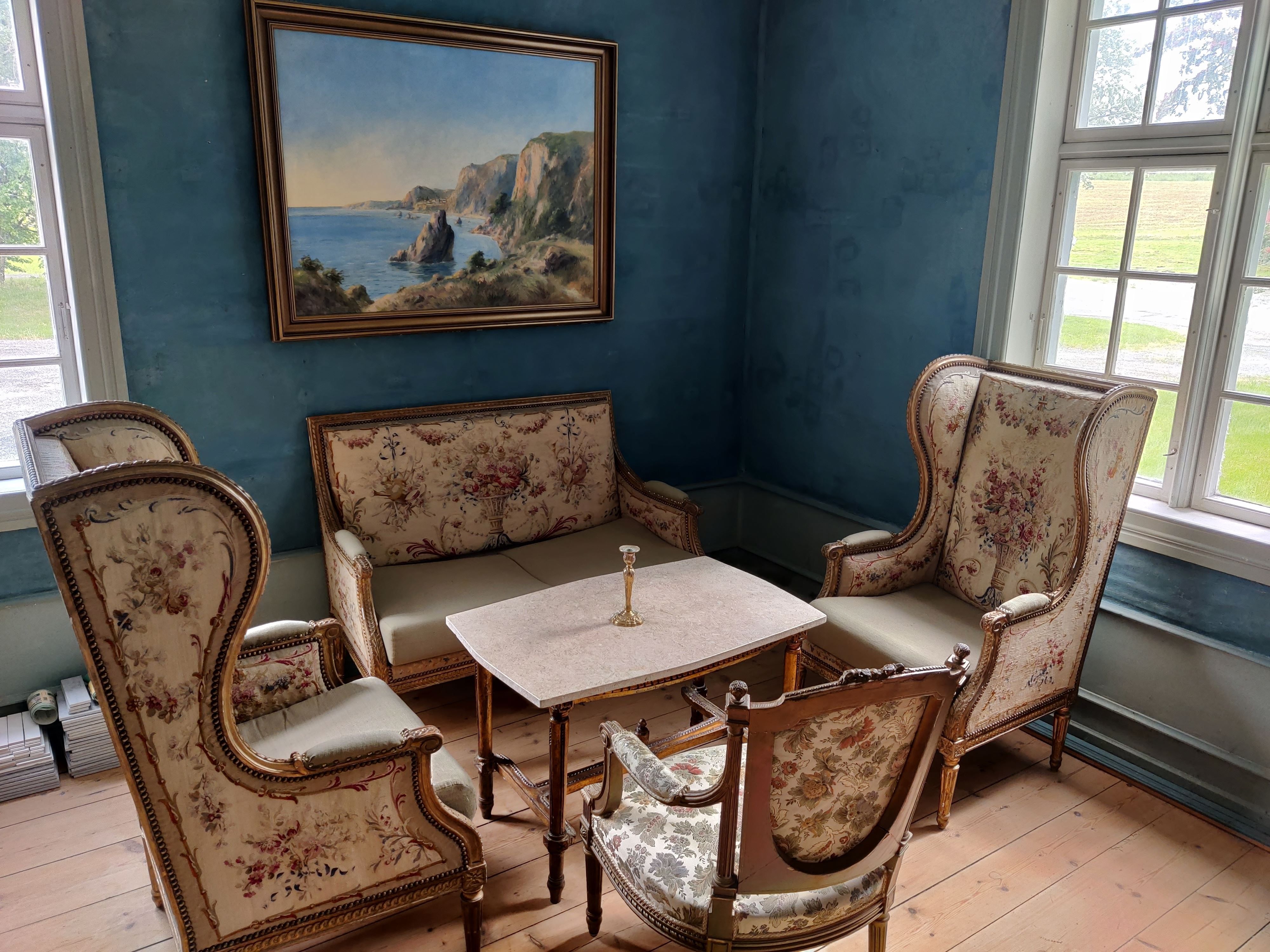 The blue salon at Skrivergaarden with classic furniture, artwork and historic details.