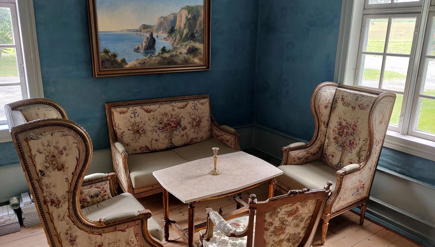 The blue salon at Skrivergaarden with classic furniture, artwork and historic details.
