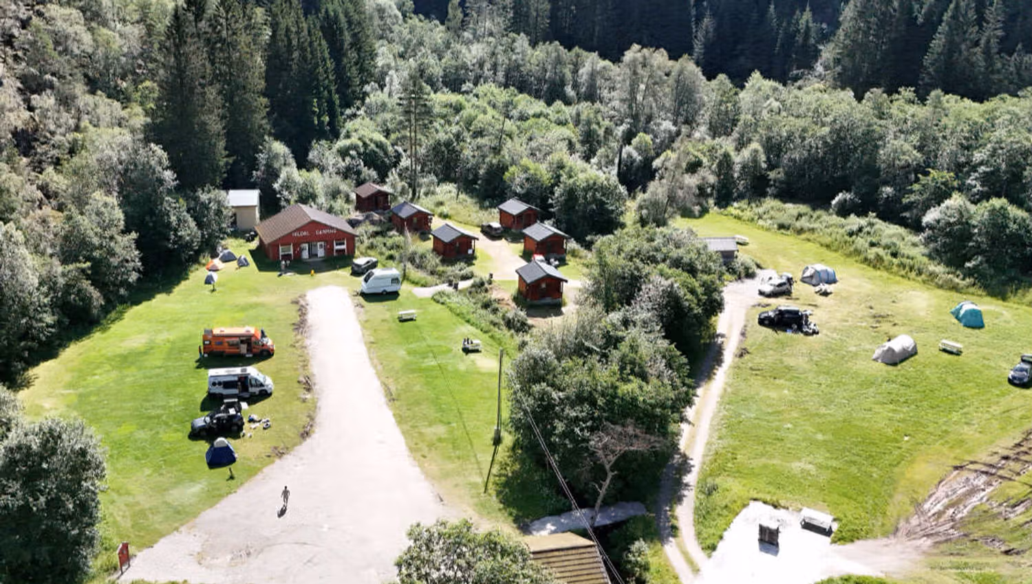 Luftaufnahme von Hildal Camping mit Hütten, Zeltplätzen und grüner Umgebung in Hardanger.