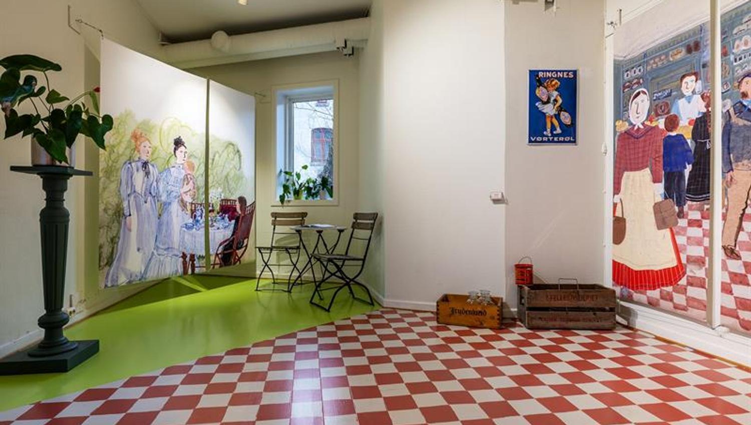 Exhibition room with illustrations, chequered flooring and historic advertising signs in a bright setting.