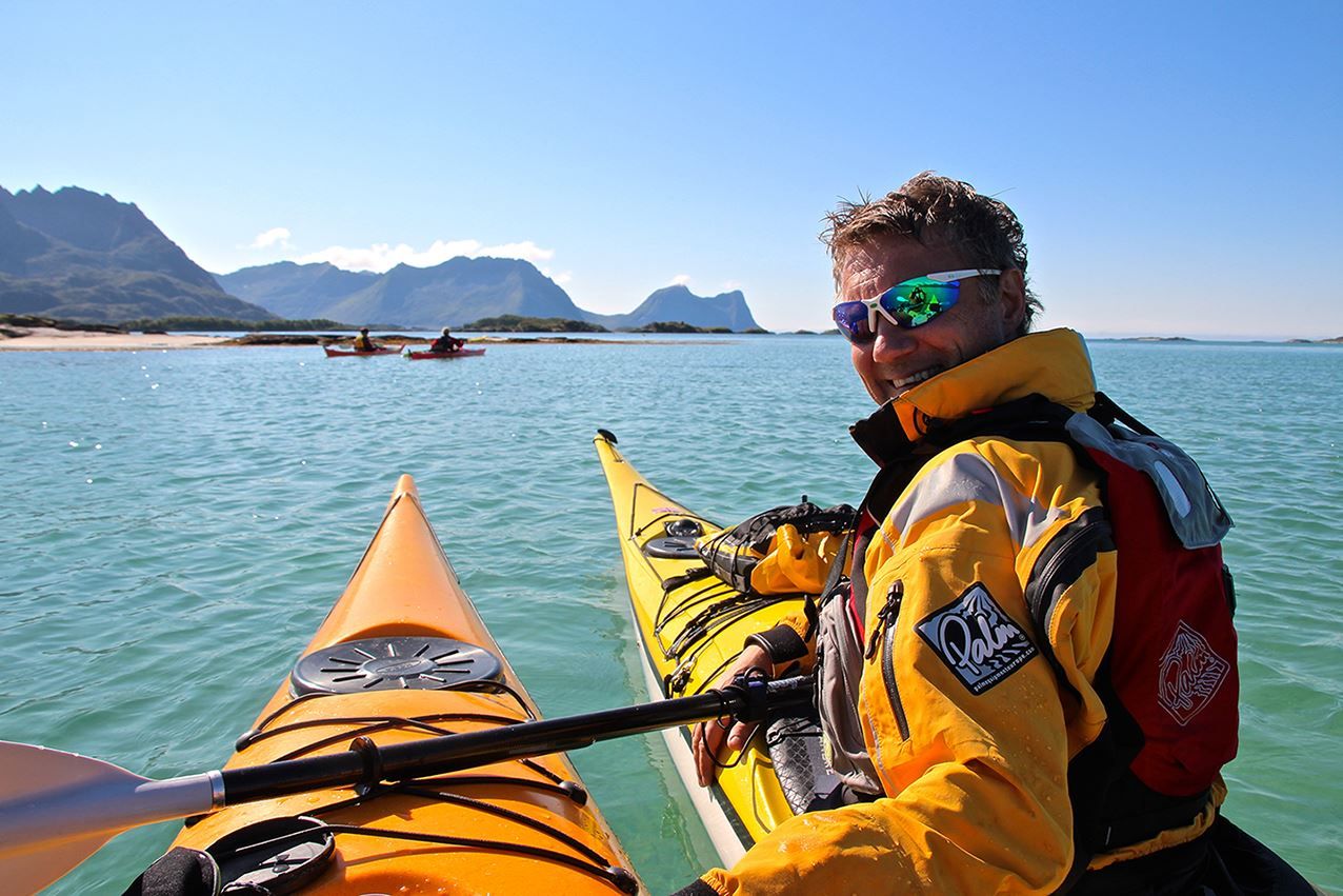A happy person kayaking in beautiful summer weather.