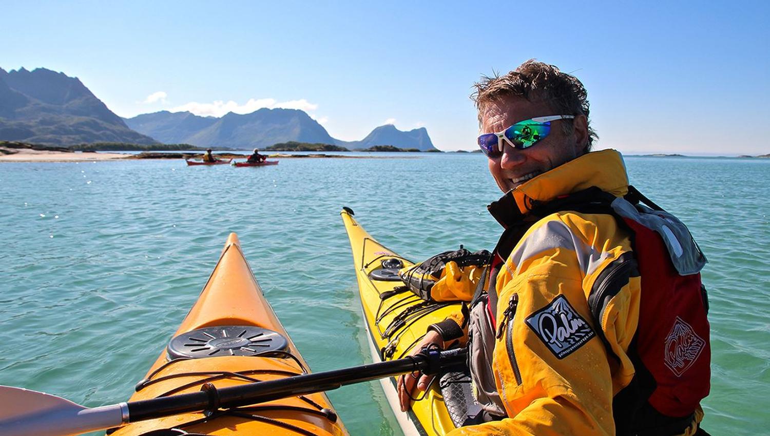 A happy person kayaking in beautiful summer weather.