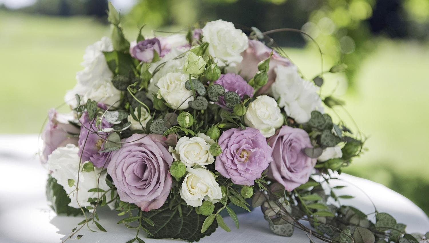 An arrangement of white and purple flowers on a white table cloth