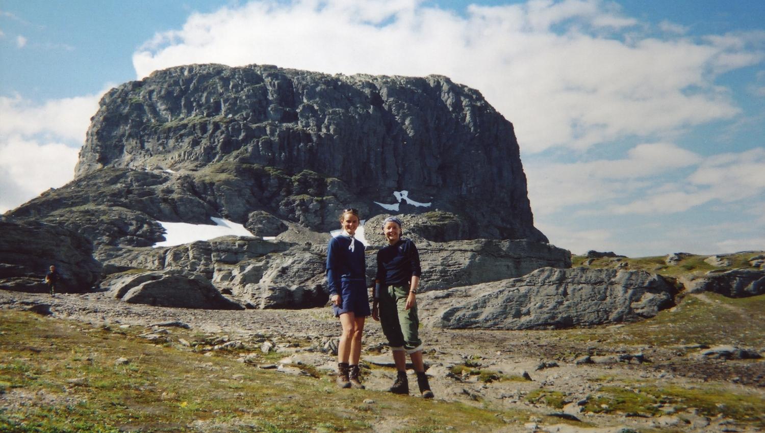 Two hikers in front of Hårteigen on Hardangervidda, an iconic mountain in the Norwegian highlands.