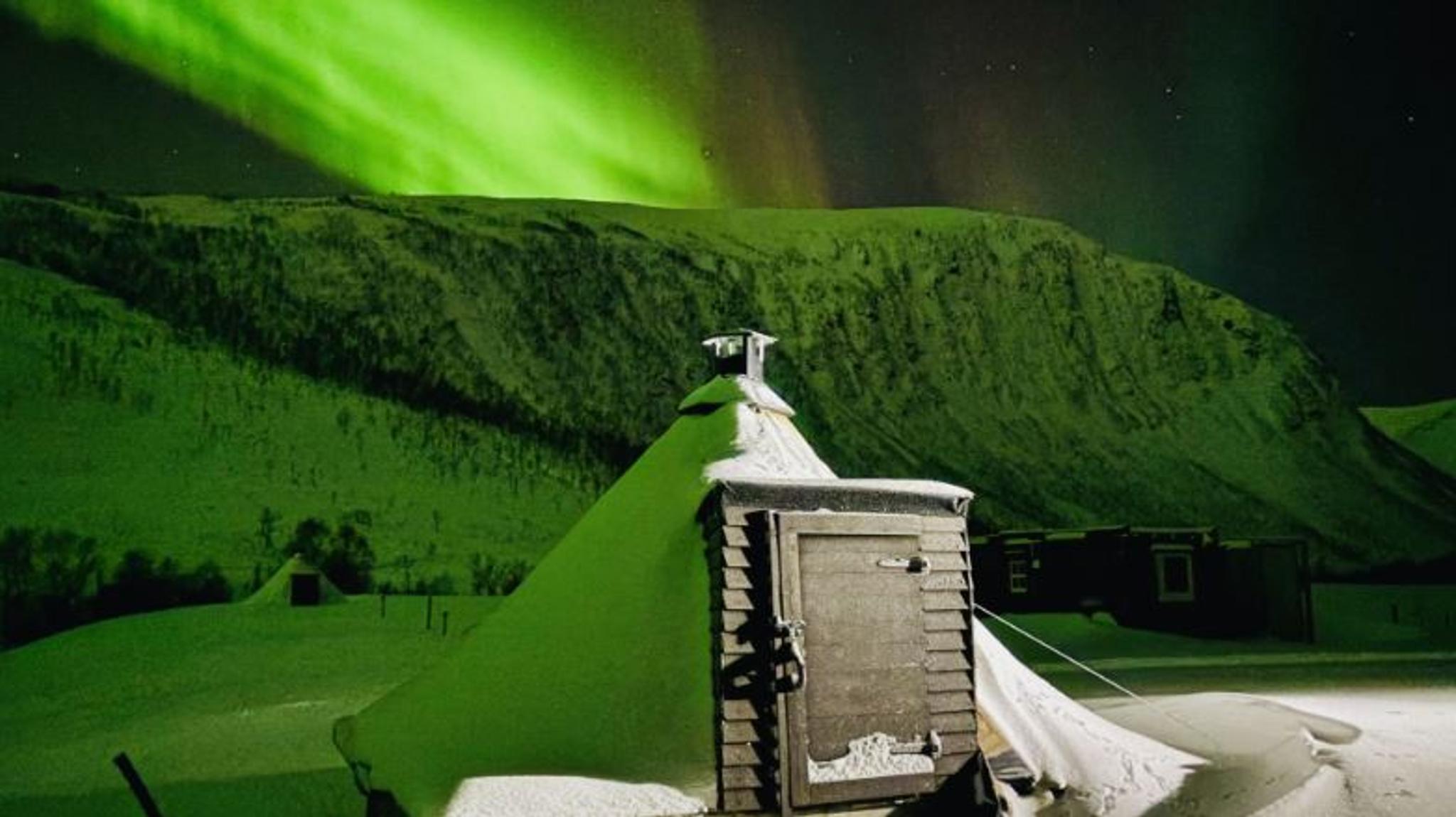 Lavvoen under nordlyset i et vinterlandskap