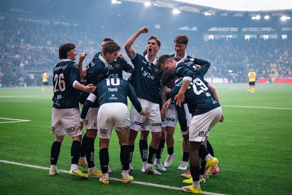Ti Viking spillere feirer et mål foran fullsatte tribuner