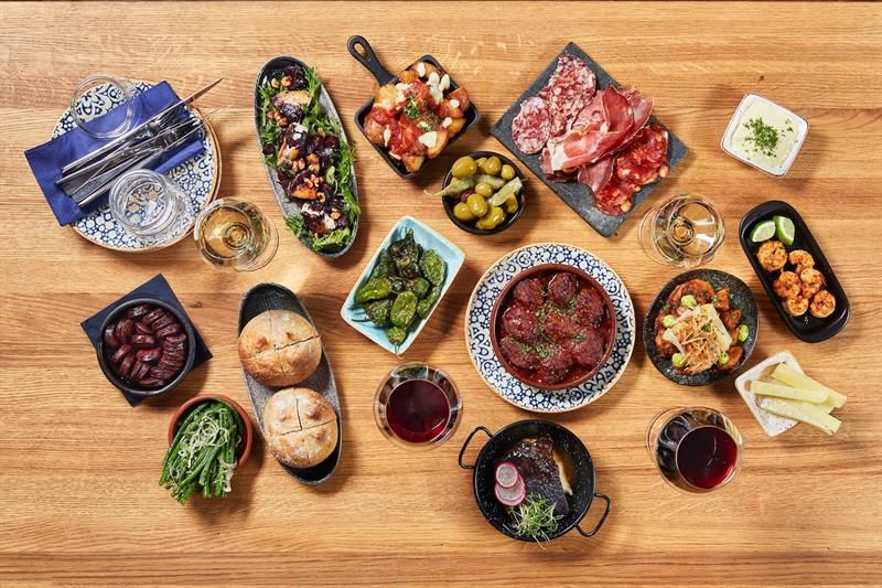 Detail photo of various tapas dishes on a wooden table.