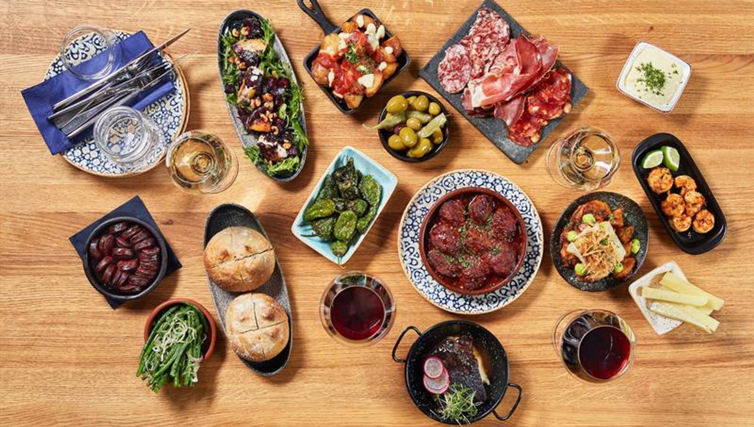 Detail photo of various tapas dishes on a wooden table.