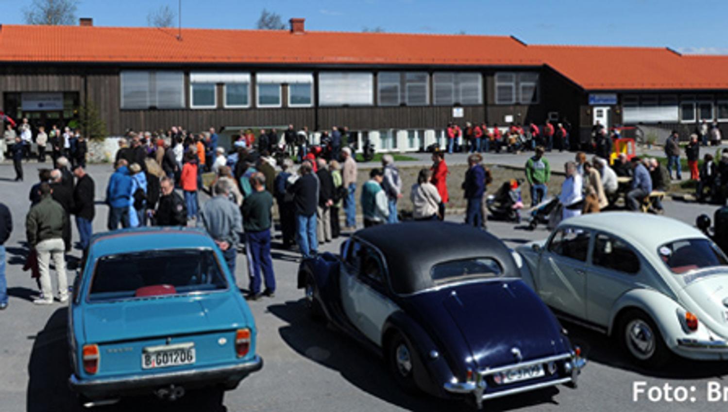 Old cars parked with people around