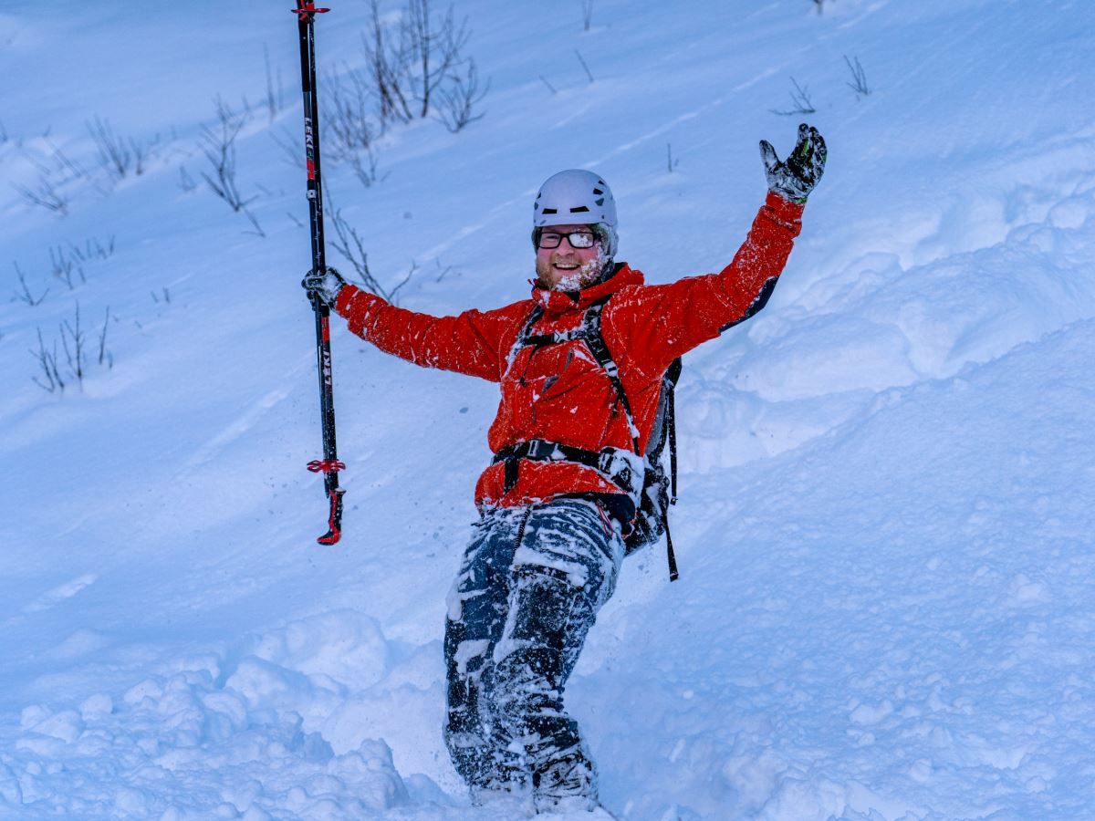 One person that has fallen on skiis, he is covered in snow.
