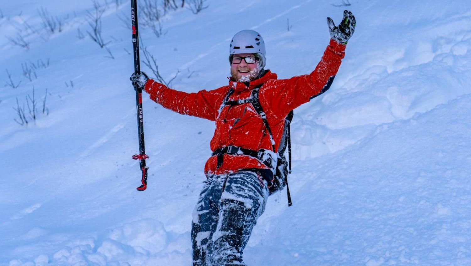 One person that has fallen on skiis, he is covered in snow.