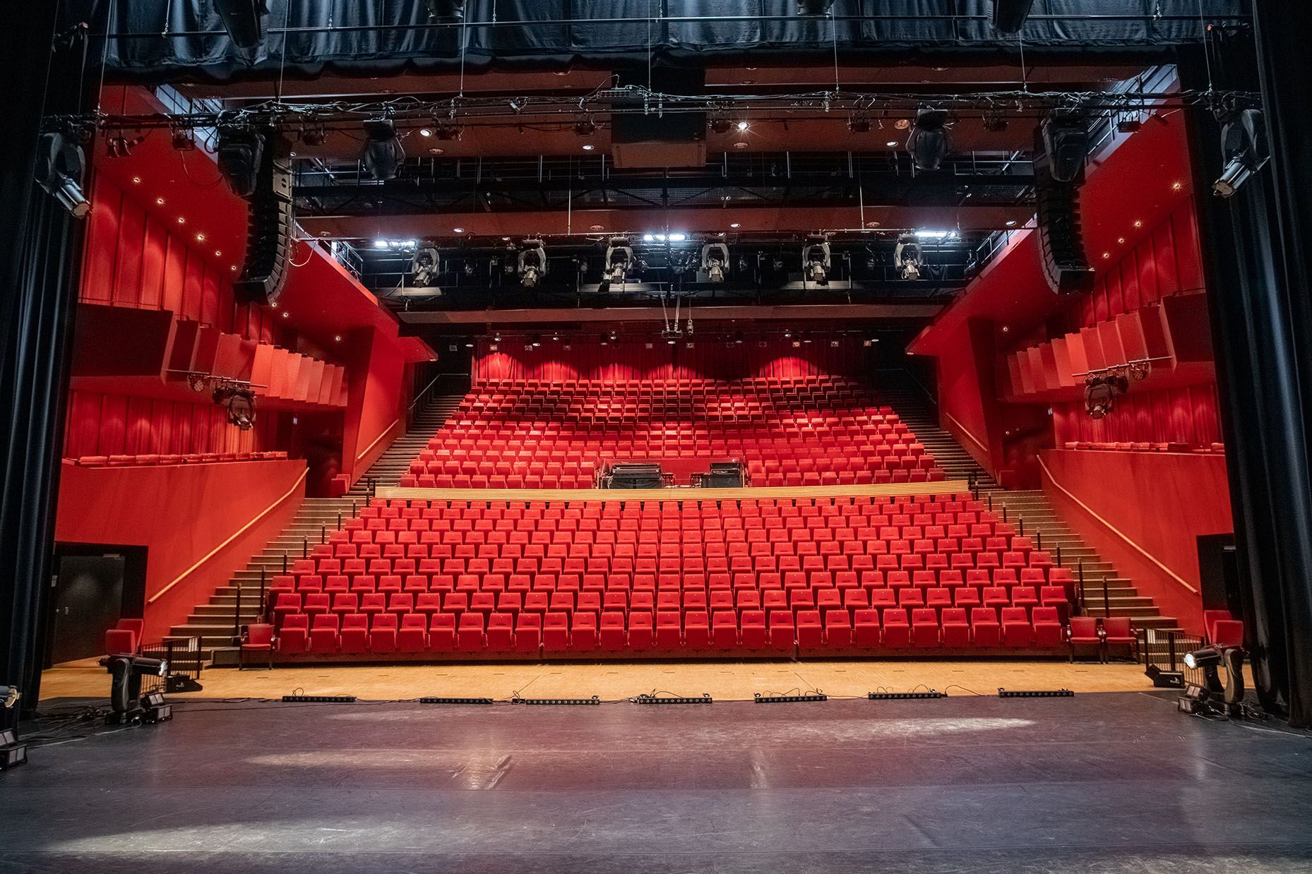 teater- og konsertsal med 20 rekker røde plysjstoler skrånende ned mot scenen.