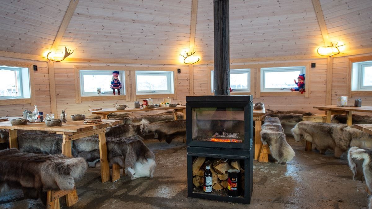 Traditional Sámi lavvu with a fireplace and seating at Tromsø Lapland’s reindeer camp near Tromsø.