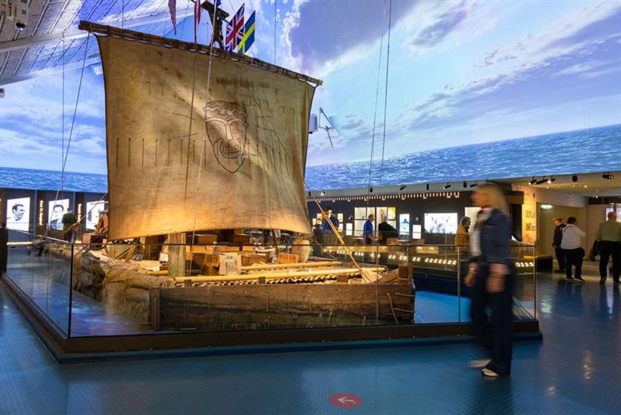 Person looking at the Kon-Tiki raft in the exhibition