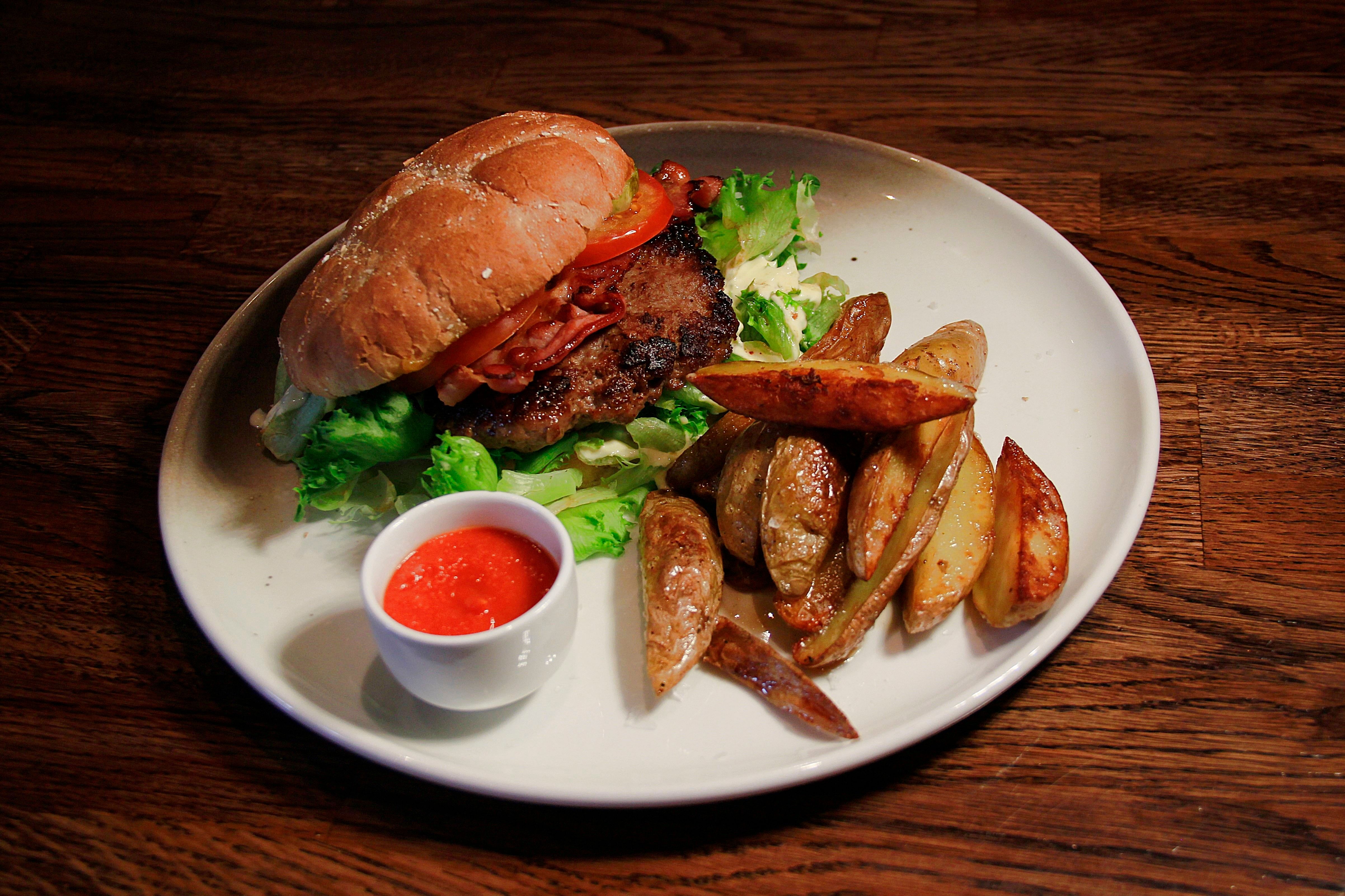 Hamburger with baked potato slices on the side