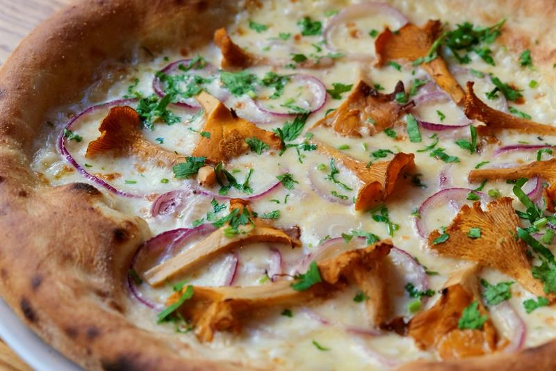 Detail of a pizza topped with chanterelle mushrooms