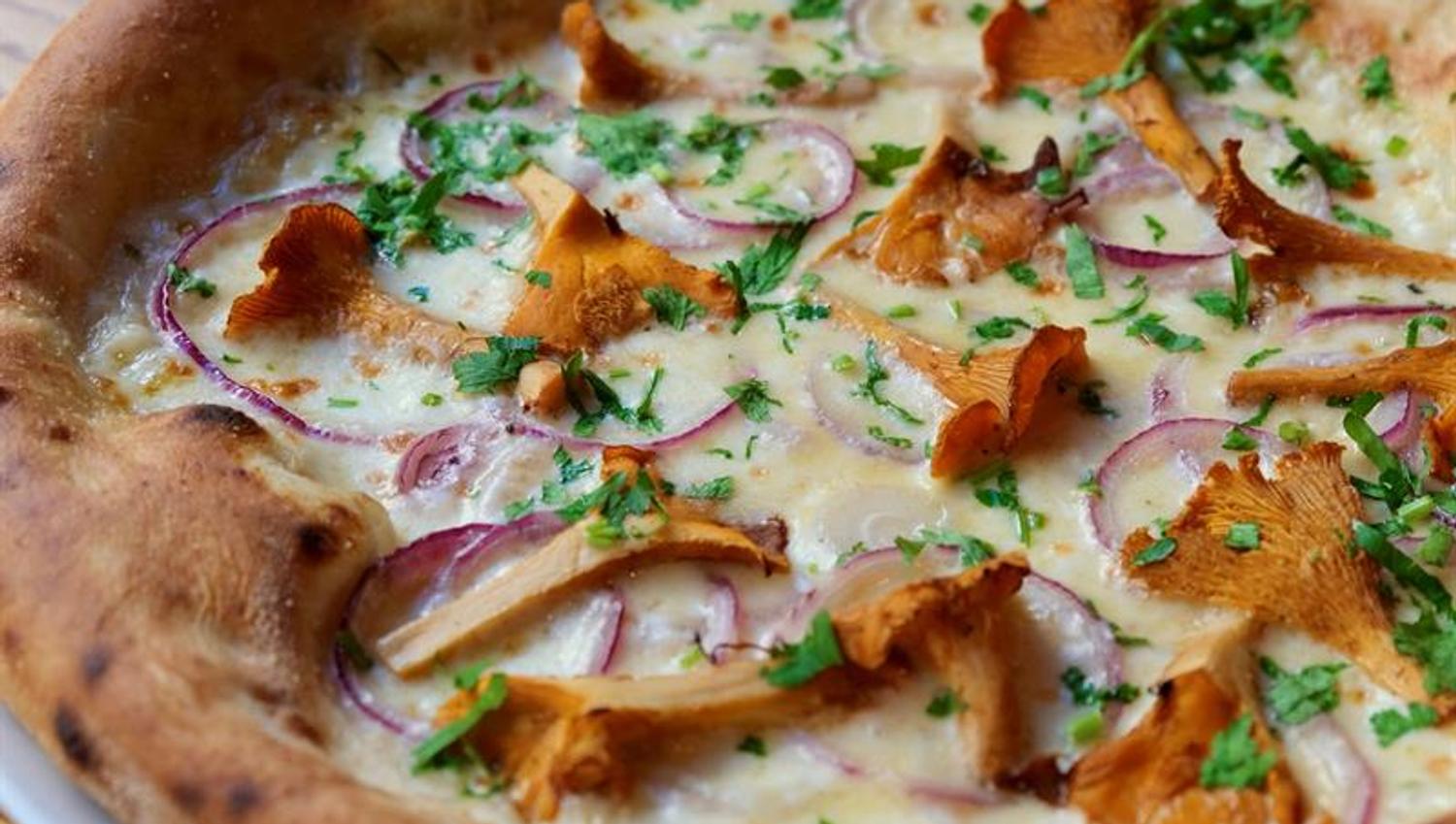 Detail of a pizza topped with chanterelle mushrooms