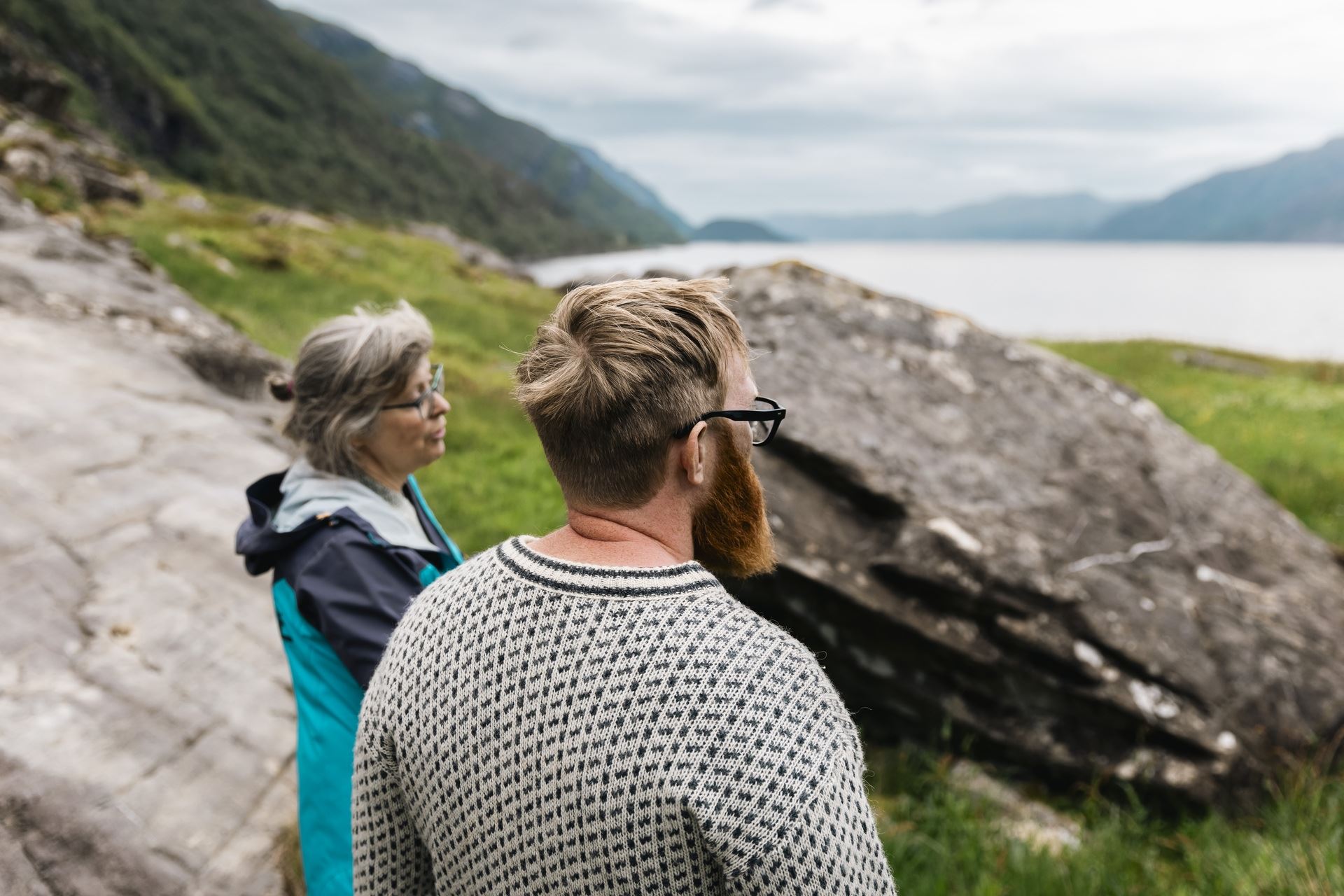 Visitors exploring the ancient rock carvings and landscape of Vingen on a guided tour.