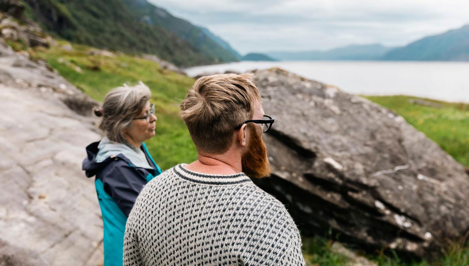 Visitors exploring the ancient rock carvings and landscape of Vingen on a guided tour.